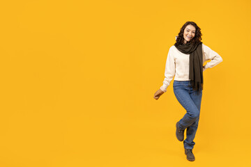 Fototapeta na wymiar Beautiful girl in warm, winter clothes on a yellow background.