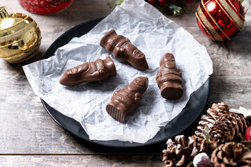 cheerful wrapped chocolate Santa Claus on wooden table