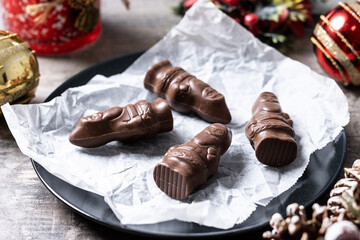 cheerful wrapped chocolate Santa Claus on wooden table