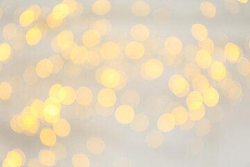 Yellow blurred lights on white background, space for text