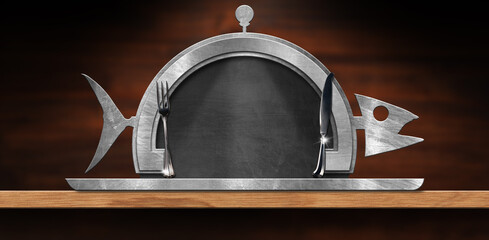 Template for a Fish Menu. Empty blackboard with steel frame in the shape of fish and serving dome with silver cutlery and copy space. On a wooden table.