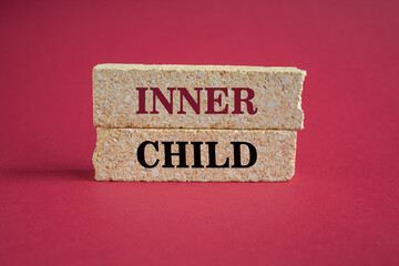 Inner child symbol. Concept words Inner child on beautiful brick block. Beautiful red background. Psychological, motivational inner child concept. Copy space.