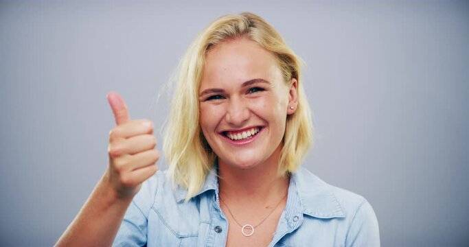 Happy woman, thumbs up and thank you for good job, success or winning isolated against a studio background. Portrait of female person or model smile and showing like emoji, yes sign or OK on mockup