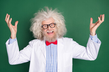 Photo of crazy funky funny scientist physician with messy hair laughing evil experiment isolated on green color background