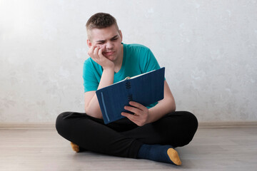 A young teenage man, European, with a white laptop. Concept freelancer, online training.