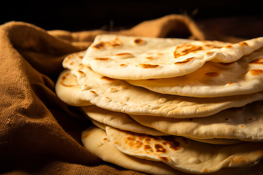 Stack of traditional naan bread on the table isolated on served table. pita bread