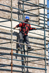 african american worker climbed on the scaffolding at a construction site of a commercial building