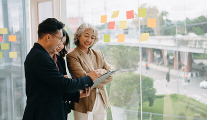 Asian business colleague business presents and explains and using laptop and tablet. Teamwork,...