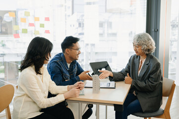 Fototapeta premium A family couple sign a lease meeting with a realtor or homeowner, purchase the first mortgage and mortgage ownership concept..