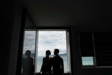 Outline of a couple of lovers posing in a room against the background of a window