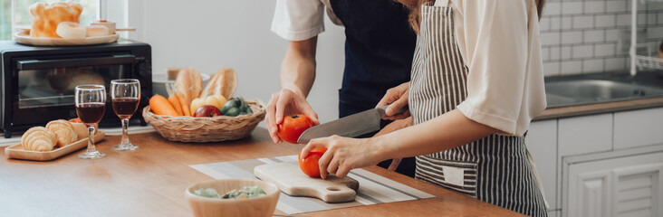 loving husband and wife is cooking dinner in home kitchen