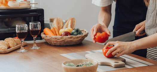 loving husband and wife is cooking dinner in home kitchen