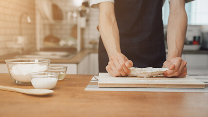 Asian couple standing in kitchen at home preparing together yummy dinner on first dating, spouses chatting enjoy warm conversation and cooking.