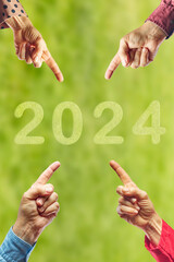 2024, People pointing to the number 2024 on green background. Happy New Year