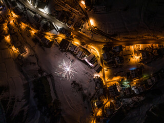 Civetta city night drone view. Fireworks in new year in dolomites . Aerial view of the city at night. Long exposure photo. Fireworks Over Dolomites