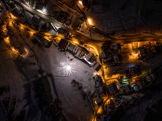 Civetta city night drone view. Fireworks in new year in dolomites . Aerial view of the city at night. Long exposure photo. Fireworks Over Dolomites