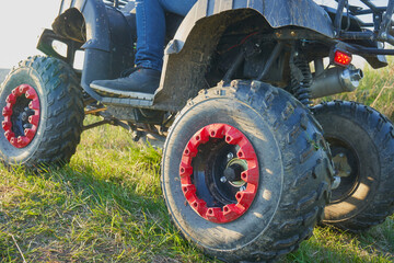 Obraz premium riding a quad bike on the grass,close-up of Quadricycle wheels on grass, dirty quad bike