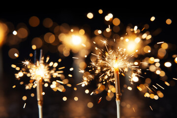 Fototapeta premium Bright sparklers on a dark background, bokeh, festive atmosphere, New Year's card