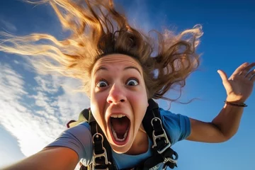 Poster Young girl screaming loudly while bungee jumping. Extreme sports © pilipphoto