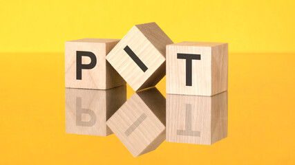 wooden blocks with text PIT on yellow background. Personal Income Tax concept