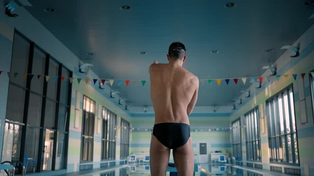 Sportsman rotates arm preparing for training in swimpool