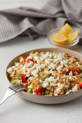 Quinoa salad with cheese and fresh vegetables on a plate. Vegetarian recipes.