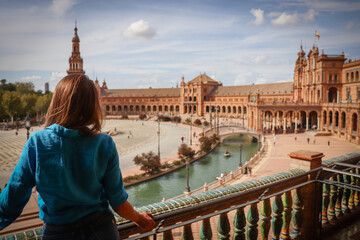 A backshot of a woman standing against the backdrop of the Park of Maria Luisa in Seville, Spain