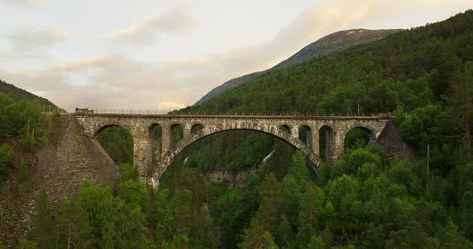 Aerial view of impressive Kylling stone bridge in lush Rauma countryside, Norway