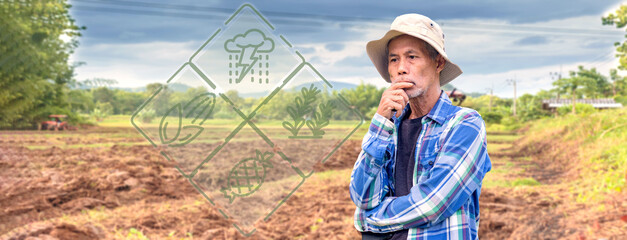 Asian farmer standing in farmland and thinking