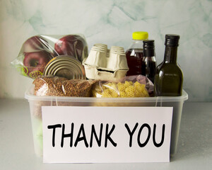 Plastic box with set of products. Charitable assistance and food delivery to those in need during...