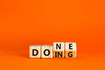 Doing and done symbol. Concept words Doing Done on wooden block. Beautiful orange table orange background. Business doing and done concept. Copy space. © Dzmitry