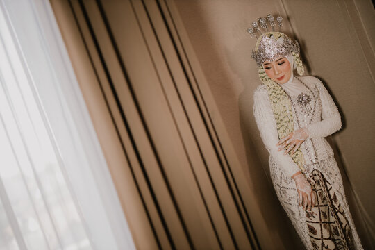 A beautiful, stylish bride using the Sundanese Siger tradition. Smile and looking at camera.