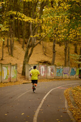 Fototapeta premium Portrait of a middle-aged man running in the park on an autumn day.
