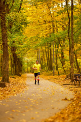Fototapeta premium Portrait of a middle-aged man running in the park on an autumn day.