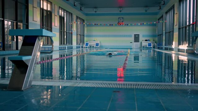 Strong swimmer trains for sports contest in clear pool water
