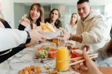 Cropped view of the man giving oranges to colleague at party table