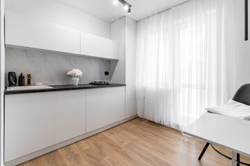 Fototapeta na wymiar Small kitchen interior in black -white with a dining area