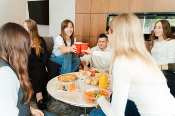 Positive group of people toasting glasses and having fun at birthday party