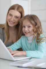 Fototapeta na wymiar Mother and daughter looking at laptop computer