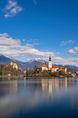 Fototapeta na wymiar Bled lake with Bled catle, church and winter Julian Alps at background