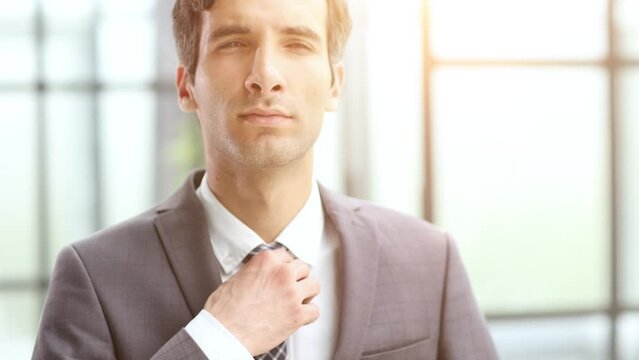 happy young businessman pulling his tie feeling good. I need fresh air.