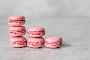 Traditional French macaroons. Pink macaroons on a gray stone background. Delicious dessert.
