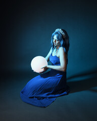 Full length portrait of beautiful female model wit blue hair wearing glamorous  fantasy ball gown...