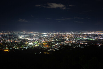 Fototapeta premium Chiang Mai night city view from the slopes of Doi Pui mountain on the way to the famous Doi Suthep temple, North Thailand.