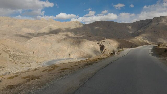 Traversing Ladakh's Mountainous Terrain Beneath a Sky Adorned with Clouds