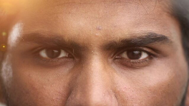 Close-up of the face and eyes of an Indian man in an emotional pose, eyes open