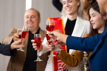 Closeup hand holding glassware. Business people celebrate making a toast on event party at office. Celebration Success Concept