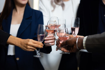 Closeup hand holding glassware. Business people celebrate making a toast on event party at office. Celebration Success Concept - obrazy, fototapety, plakaty