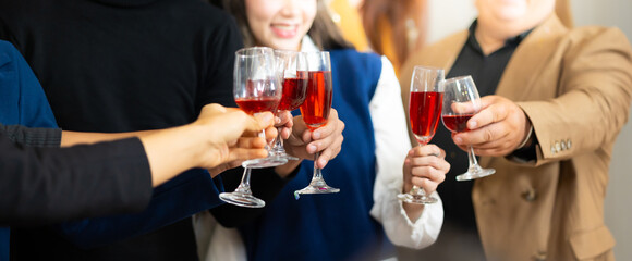 Closeup hand holding glassware. Business people celebrate making a toast on event party at office. Celebration Success Concept