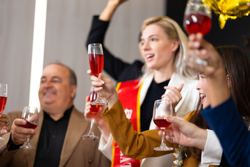 Closeup hand holding glassware. Business people celebrate making a toast on event party at office. Celebration Success Concept